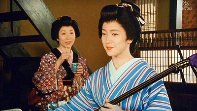 余裕の表情で三味線をつま弾く蔦吉(若村麻由美)